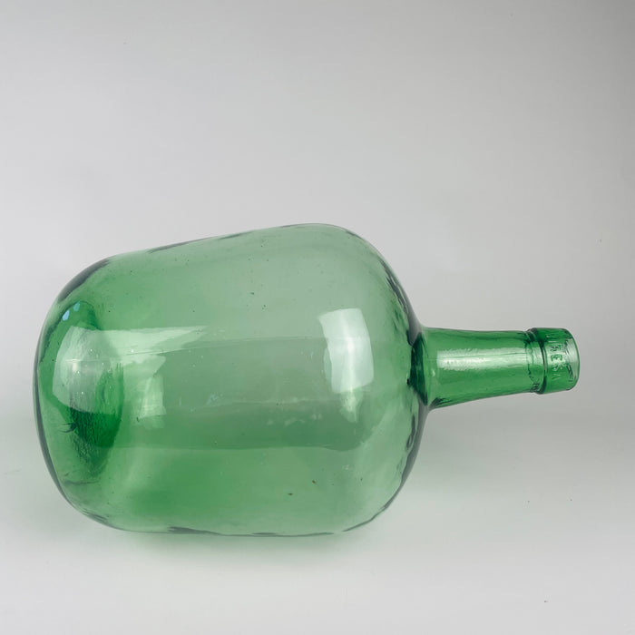 Embossed 5 L capacity mark beside the VIRESA name on the neck of this circa 1960s Spanish green glass carboy. The mould blown demijohn was formed as a durable container for wine and other liquids, with a thick rounded lip, tapered neck and transparent sea green body. Its compact proportions make it suitable as a table vase or console centerpiece.