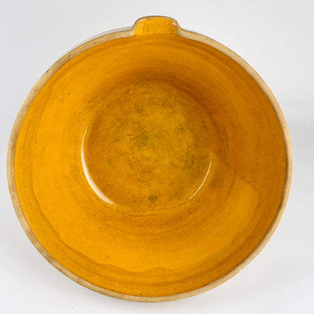 Side view of the antique French terracotta bowl highlighting the partially glazed exterior band and raw terracotta lower body. The warm amber ochre interior contrasts with the natural clay beneath, illustrating historic firing practices of Southwest and Central France. This large piece is ideal for French country decor, rustic table settings, or as a bold accent on kitchen islands and open shelving.