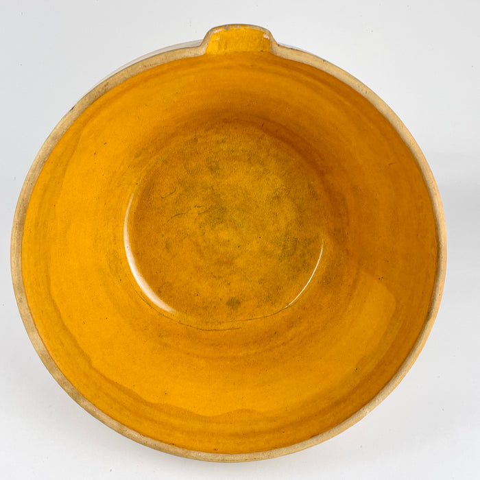 Side view of the antique French terracotta bowl highlighting the partially glazed exterior band and raw terracotta lower body. The warm amber ochre interior contrasts with the natural clay beneath, illustrating historic firing practices of Southwest and Central France. This large piece is ideal for French country decor, rustic table settings, or as a bold accent on kitchen islands and open shelving.
