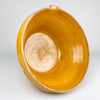 A detailed view of the interior of this warm amber ochre glazed terracotta bowl reveals the rich colour, glossy surface and characteristic glaze shading associated with antique French culinary pottery. The thick terracotta walls and gentle curves show the functional design of a traditional jatte or terrine used in rural kitchens. This piece complements rustic kitchen decor, country cottage decor, and farmhouse decor.