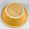 Underside photograph showing the raw terracotta base, firing ring, and wear marks typical of 19th century French terracotta. The unglazed foot and textured clay surface reinforce the authenticity of this warm amber ochre glazed bowl, making it suitable for collectors of French country ceramics and rustic pottery.