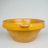 Top view photograph capturing the full interior surface of the warm amber ochre glazed bowl, showing firing variation and glaze movement. This antique French terracotta bowl is suitable for display on shelves, tables or kitchen counters within rustic home decor or French country settings.