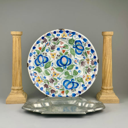 Plate styled leaning against a rustic wooden wall, demonstrating decorative versatility in farmhouse, Mediterranean, or Spanish eclectic home settings.